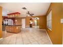 Dining room area features tile flooring, mirrored archway, and a view into the kitchen at 9130 Dresden Ln, Port Richey, FL 34668
