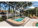 Inviting screened-in hot tub perfect for unwinding, with serene backyard views and lounge chairs at 9322 Wellington Park Cir, Tampa, FL 33647