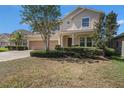 Inviting two-story home featuring a well-manicured lawn, stone accents, and a convenient two-car garage at 1018 Tracey Ann Loop, Seffner, FL 33584