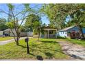 Inviting single-story home with a lush green lawn and mature trees providing shade at 1021 11Th Nw Ave, Largo, FL 33770