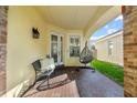 Relaxing front porch area with brick floors, comfortable seating, and decorative egg chair swing at 10602 Rochester Way, Tampa, FL 33626