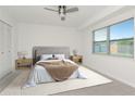 Well-lit bedroom with a ceiling fan, neutral tones, and large window for natural light at 10705 Knollsway Ct, Tampa, FL 33625