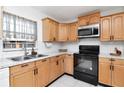 Classic kitchen featuring wooden cabinets, subway tile backsplash, and modern black appliances at 10705 Knollsway Ct, Tampa, FL 33625