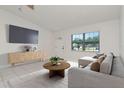 Bright living room with a neutral palette, modern furniture, and large windows offering ample natural light at 10705 Knollsway Ct, Tampa, FL 33625