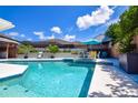 Beautiful backyard pool and patio area with a table, chairs, spa, and palms at 11777 90Th Ave, Seminole, FL 33772