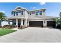 Attractive two-story home boasting a spacious three-car garage and a well-maintained front yard at 12664 Flatwood Creek Dr, Gibsonton, FL 33534