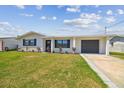 Charming single-story home featuring a well-maintained lawn, attached garage, and a welcoming front entrance at 13617 Frances Ave, Hudson, FL 34667