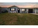 Charming single-story home featuring a well-maintained lawn, attached garage, and a welcoming front entrance at 13617 Frances Ave, Hudson, FL 34667
