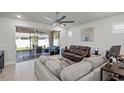 Comfortable living room with a ceiling fan, tile flooring, and access to the outdoor patio at 15429 Caravan Ave, Odessa, FL 33556