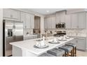 Modern kitchen with stainless steel appliances, a central island, and elegant countertops and backsplash at 1880 Longliner Loop, Wesley Chapel, FL 33543