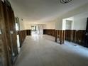 Spacious living room showing the studs, and tile floor with a sliding glass door at 200 Country Club Dr # 1101, Largo, FL 33771