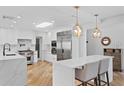 Bright, modern kitchen with white cabinetry, stone countertops, stainless steel appliances, and wood flooring at 207 S Coolidge Ave, Tampa, FL 33609