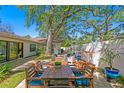 Outdoor patio with a dining area and lounge seating surrounded by mature trees at 207 S Coolidge Ave, Tampa, FL 33609