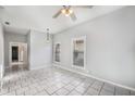 Living room showcasing tile flooring, a ceiling fan, and an open doorway at 2317 W Chestnut St, Tampa, FL 33607