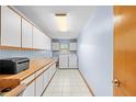 Spacious laundry room offers ample storage with white cabinets, a utility sink, and modern appliances at 24076 Ragan Dr, Brooksville, FL 34601