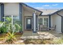 Inviting front porch with seating, decorative plants, and a stylish front door with glass inserts at 2554 Brimhollow Dr, Valrico, FL 33596