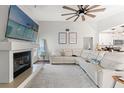 Open-concept living room with a fireplace, TV, and comfortable white seating next to an adjacent kitchen at 2554 Brimhollow Dr, Valrico, FL 33596
