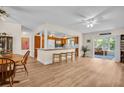 Open concept living room and kitchen area with light colored flooring and ceiling fans at 2814 Lomond Dr, Palm Harbor, FL 34684