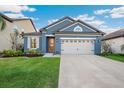 Charming blue single-Gathering home featuring a well-manicured lawn and a two-car garage at 30647 Walker Cup Pl, Wesley Chapel, FL 33543
