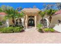 Close up of the front entrance featuring a double door entry, stone columns, and mature landscaping at 3607 Berger Rd, Lutz, FL 33548