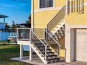 Close-up of home's staircase entrance and a boat parked nearby on the well-maintained lawn at 4116 Diaz Ct, Hernando Beach, FL 34607