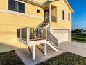 Close-up of home's staircase entrance leading to the second floor, adjacent to a garage and driveway at 4116 Diaz Ct, Hernando Beach, FL 34607