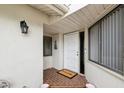 Front entrance with an open white door, a 'Welcome' mat, and a charming exterior at 456 Lakeview Dr # 5, Palm Harbor, FL 34683
