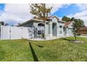 Side view of a light blue single-story home with a fenced yard and green grass at 5189 Brackenwood Dr, Spring Hill, FL 34609