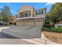 Home exterior with a stone-clad facade, a balcony, three garages, and a concrete driveway at 5717 Kingletsound Pl, Lithia, FL 33547