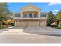A beautiful townhome exterior with a stone-clad facade, balcony, three garages, and a well-kept driveway at 5717 Kingletsound Pl, Lithia, FL 33547