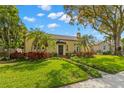 Charming yellow home with a spanish tile roof surrounded by mature trees and landscaping at 646 16Th Ne Ave, St Petersburg, FL 33704