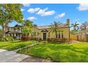 Quaint yellow home showcasing mature trees, a manicured lawn, and unique landscaping at 646 16Th Ne Ave, St Petersburg, FL 33704