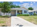 Charming blue bungalow with a covered porch, yellow front door, and an attached garage at 7113 S Mascotte St, Tampa, FL 33616