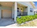 Charming front porch of this blue home featuring an attached garage and decorative landscaping at 7113 S Mascotte St, Tampa, FL 33616