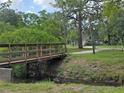 Scenic community foot bridge surrounded by lush landscaping and mature trees at 754 71St N Ave, St Petersburg, FL 33702