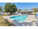 Backyard features a refreshing pool, lounge chairs, and a screened-in patio at 827 Virginia St, Dunedin, FL 34698