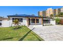 Beautiful home boasts updated exteriors and new roof, highlighted by a green lawn and palms at 864 Mandalay Ave, Clearwater Beach, FL 33767