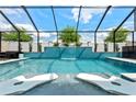 This stunning pool features a cascading waterfall, in-pool loungers, and ample patio seating under a screened enclosure at 8720 Drummer Plank Dr, Wesley Chapel, FL 33545