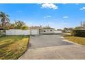 Exterior showcasing the home's front yard, driveway, and charming facade at 8801 Sunlit Cove Ne Dr, St Petersburg, FL 33702