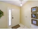 Bright foyer features a white door, tile flooring, and decorative wall art at 12024 Stone Crossing Cir, Tampa, FL 33635