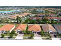 A panoramic aerial view showing homes and community amenities including a community lagoon at 16913 Clear Cork Dr, Wimauma, FL 33598