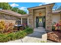 Inviting front entrance with a decorative fountain, colorful landscaping, and a stylish, covered entryway at 1807 Tawnee Pl, Brandon, FL 33510