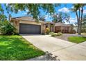A well-maintained, one-story brick home featuring an attached garage and an inviting driveway with lush landscaping at 1807 Tawnee Pl, Brandon, FL 33510