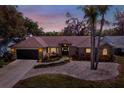 Charming single-story brick home with landscaped front yard and attached two-car garage at dusk at 1807 Tawnee Pl, Brandon, FL 33510