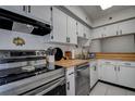 Bright kitchen featuring stainless steel appliances, white cabinetry, and butcher block countertops at 1836 Bough Ave # C, Clearwater, FL 33760