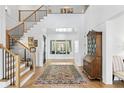 Bright foyer showcasing hardwood floors, a staircase with iron railings, and a clear view to the backyard at 1903 S Cardenas Ave, Tampa, FL 33629