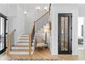 Elegant staircase featuring wooden steps, a black iron railing, and stylish wall sconces at 1903 S Cardenas Ave, Tampa, FL 33629