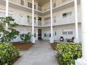 Three-story condo with a white facade, including a courtyard and plants at 2449 Columbia Dr # 53, Clearwater, FL 33763