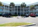 Three-story condo with a white facade, supported by palm trees at 2449 Columbia Dr # 53, Clearwater, FL 33763
