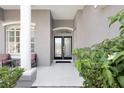 Inviting front porch with seating area and beautiful double-door entry, surrounded by lush landscaping at 2863 Duncan Tree Cir, Valrico, FL 33594